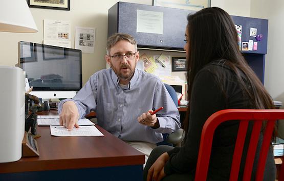 A professor meets with a student in his office