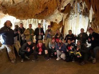 Group of students posing inside a cave
